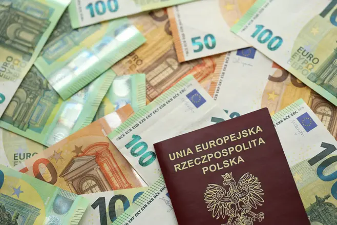 A Polish passport on a pile of euro banknotes